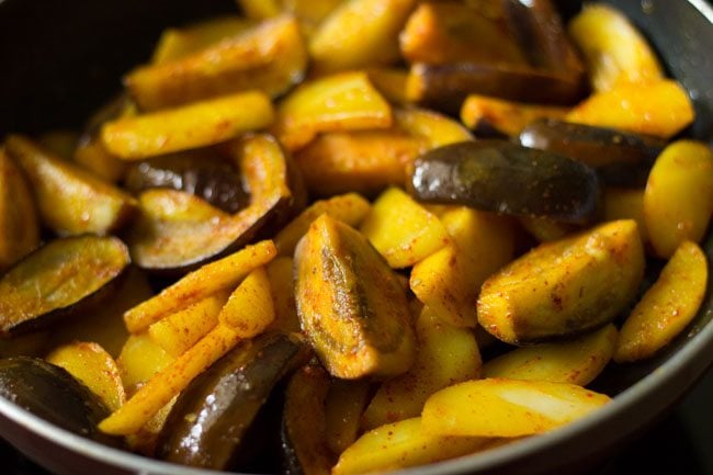 mixing spices with aloo baingan