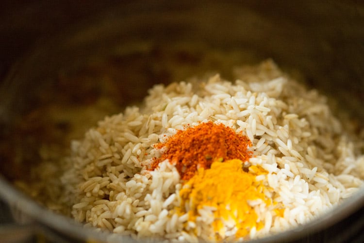turmeric and red chili powder added to rice
