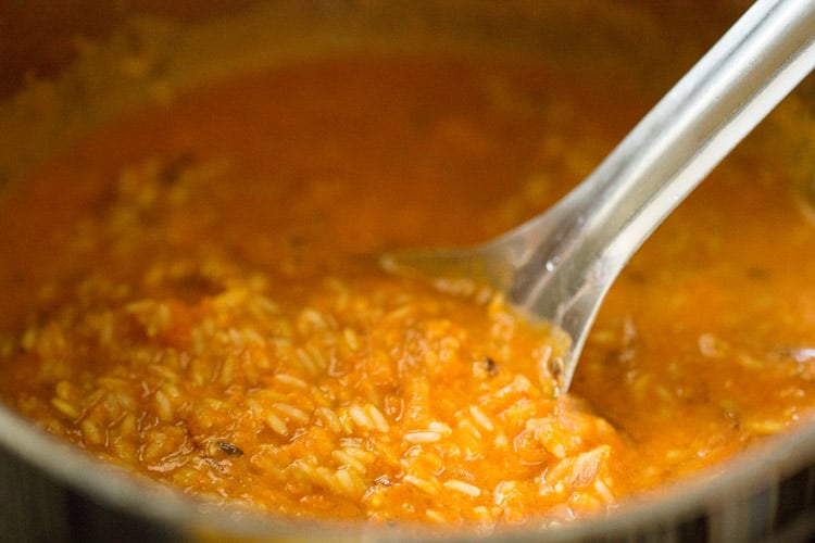 mix the tomato coconut masala paste with the rice in the pan