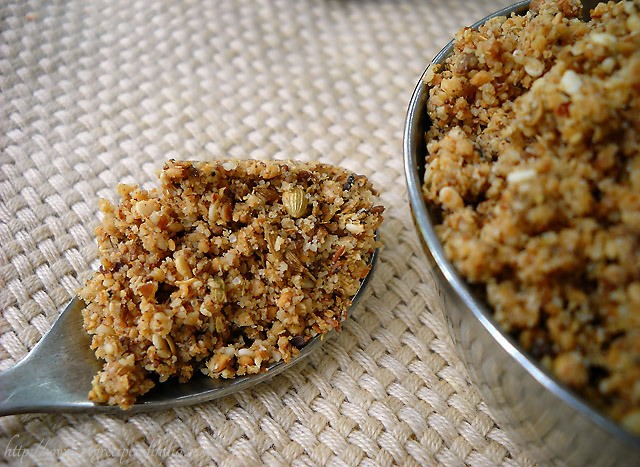 dukkah in a spoon and some kept in a bowl on the right side. 