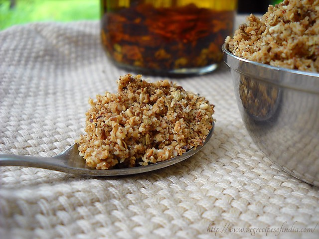 duqqa dukkah in a spoon and some kept in a bowl on the right side.