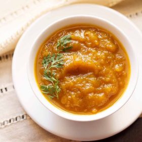 kaddu ki sabzi served on a white bowl placed on a white tray.