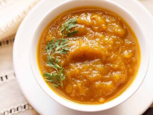 kaddu ki sabzi served on a white bowl placed on a white tray.