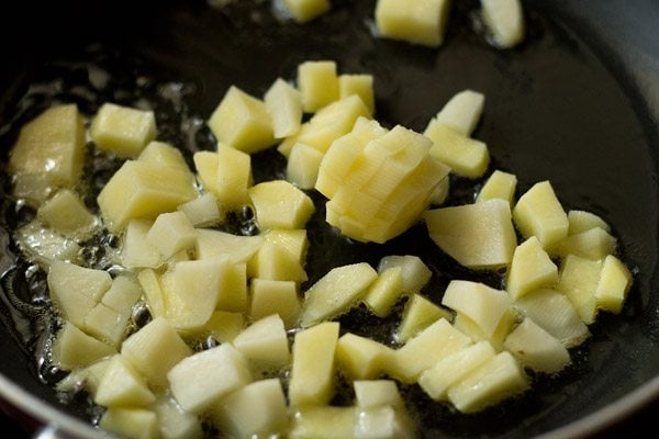 pan frying potato cubes in hot oil in a pan. 