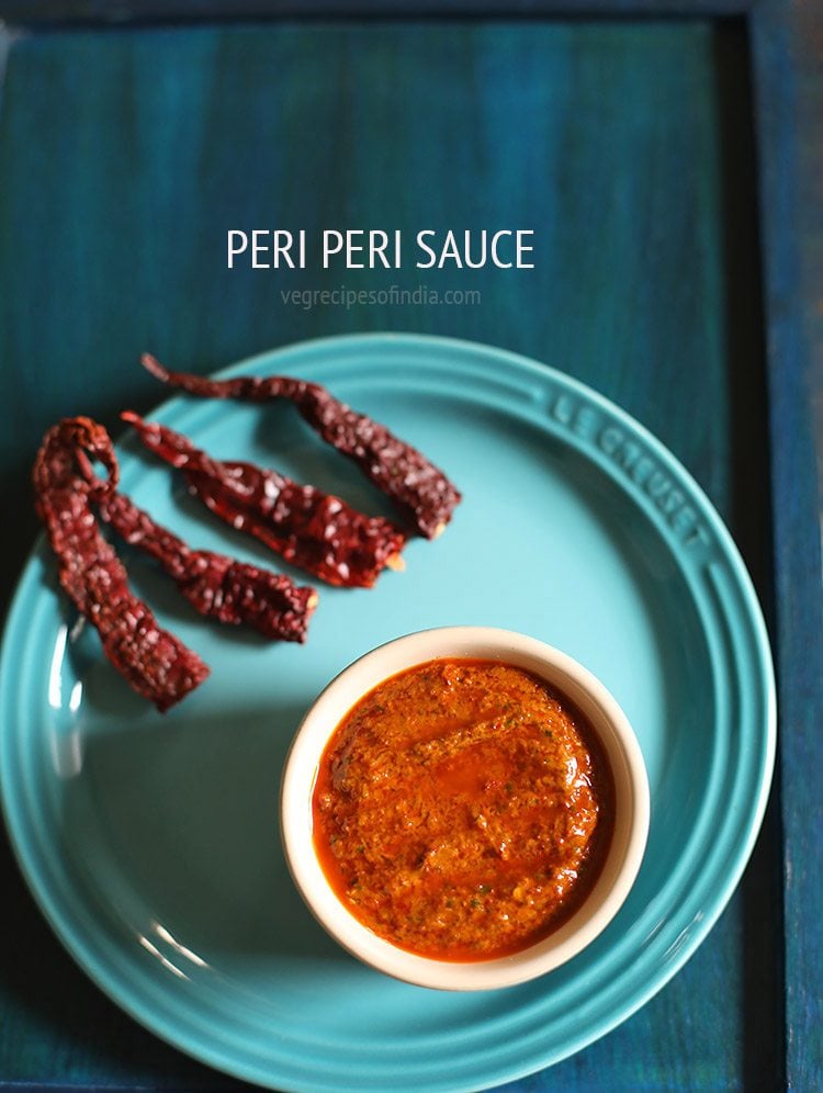 peri peri sauce in a bowl on a blue plate with text layovers.