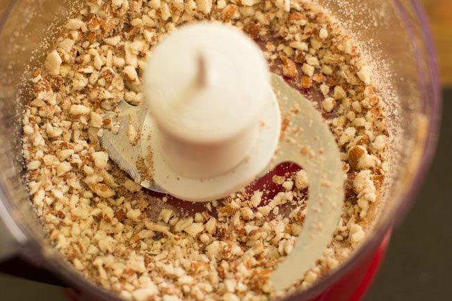 nuts are roughly chopped in base of food processor.