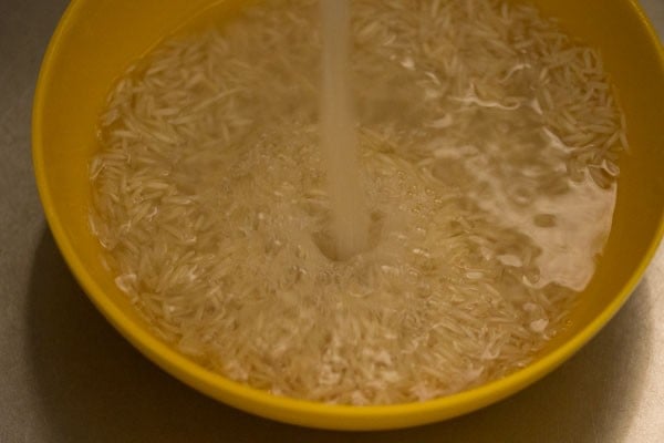 basmati rice being rinsed in running water