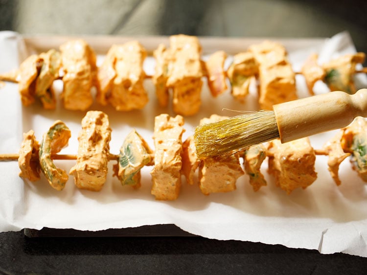 brushing oil on the paneer cubes, onions and capsicum