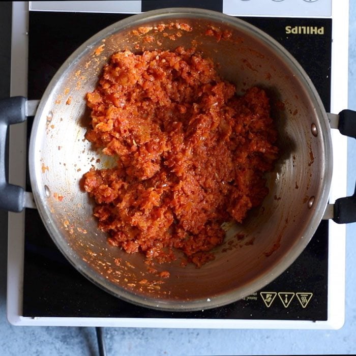 tomatoes being sautéed until thick and pasty to make kadai paneer