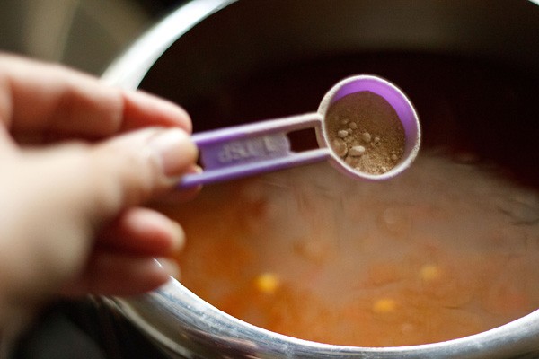 adding dry mango powder to rajma masala