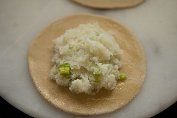 grated cauliflower mix added to rolled paratha