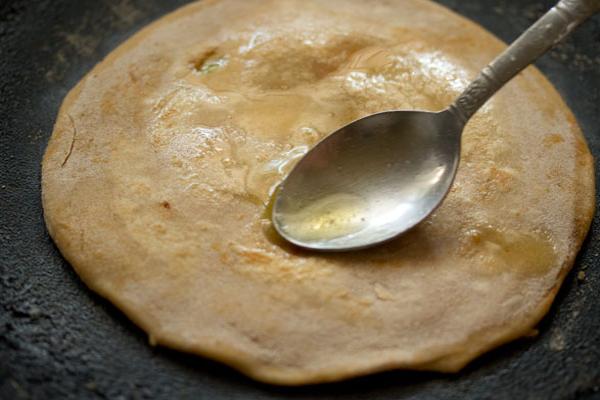 applying ghee on second side of gobi paratha