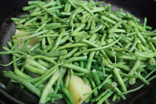 sautéing chopped radish pods and diced potatoes in the pan. 