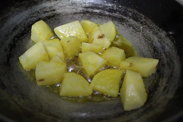 diced potato added in hot mustard oil in a pan for moongre recipe. 