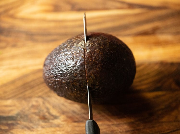 cutting ripe avocado in half. 