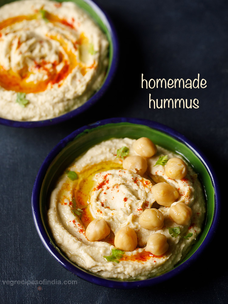 hummus served on a black bowl garnished with cooked chickpeas