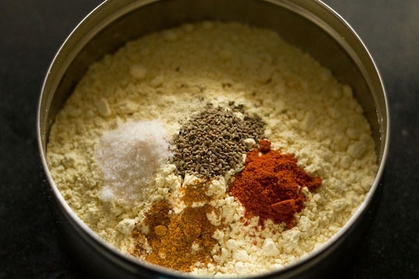 gram flour, salt, carom seeds and spice powders in a steel bowl