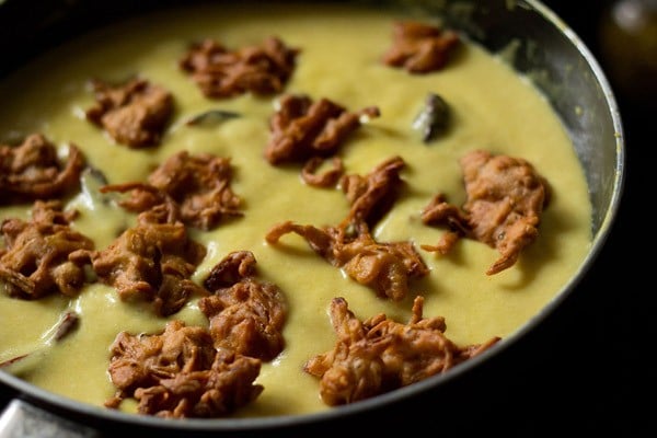 onion pakora added to kadhi to make kadhi pakora