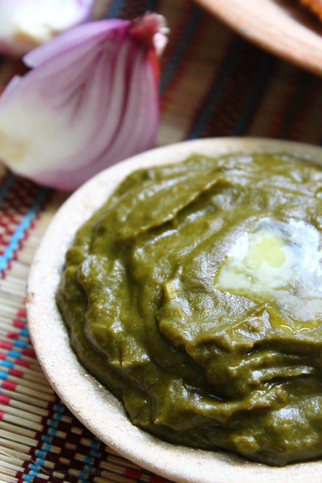 Palak saag in a earthen bowl with melted butter on top.