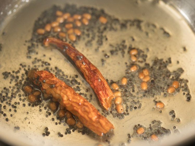 frying dried red chilies for making thakkali rasam. 