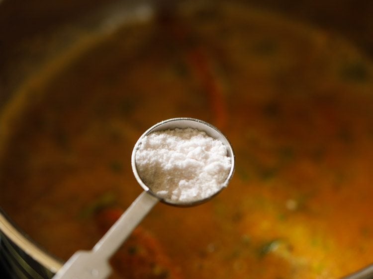 adding salt to tomato rasam. 