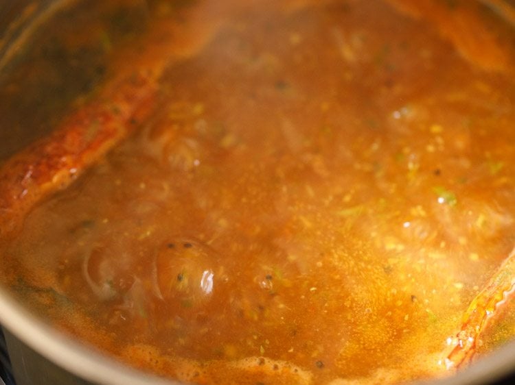 tomato rasam simmering in pan