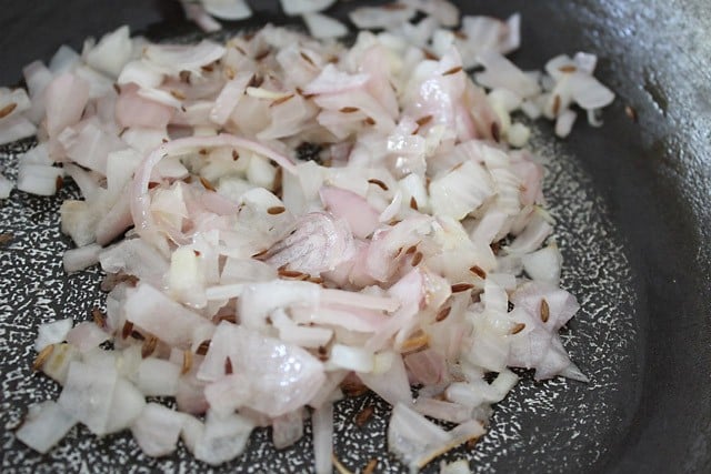 frying onions with cumin seeds in hot oil in a pan. 