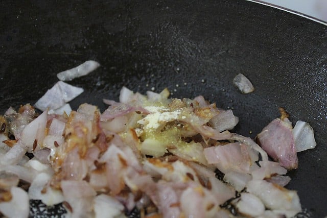 asafoetida added to the frying onions in the pan. 