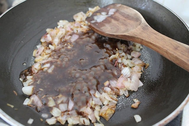 tamarind-date chutney added to the frying onions in the pan. 