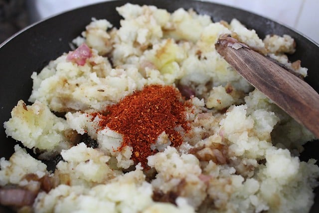 dabeli masala powder added to the mashed potatoes in the pan. 