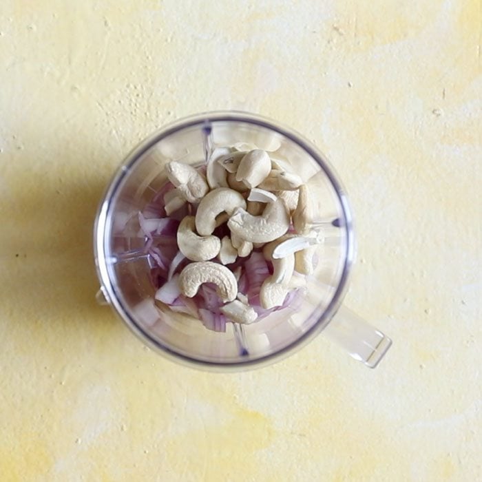 raw cashews added to grinder jar.