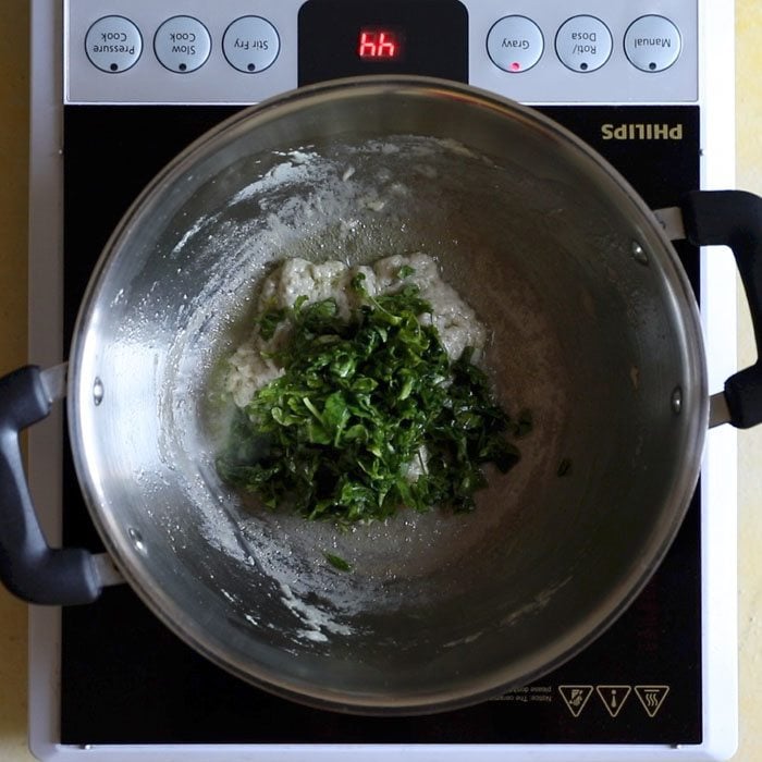 methi leaves added to pan with paste.