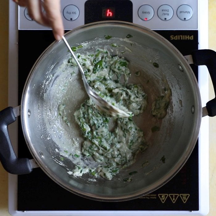 sautéing fenugreek leaves with paste for making methi matar malai recipe.