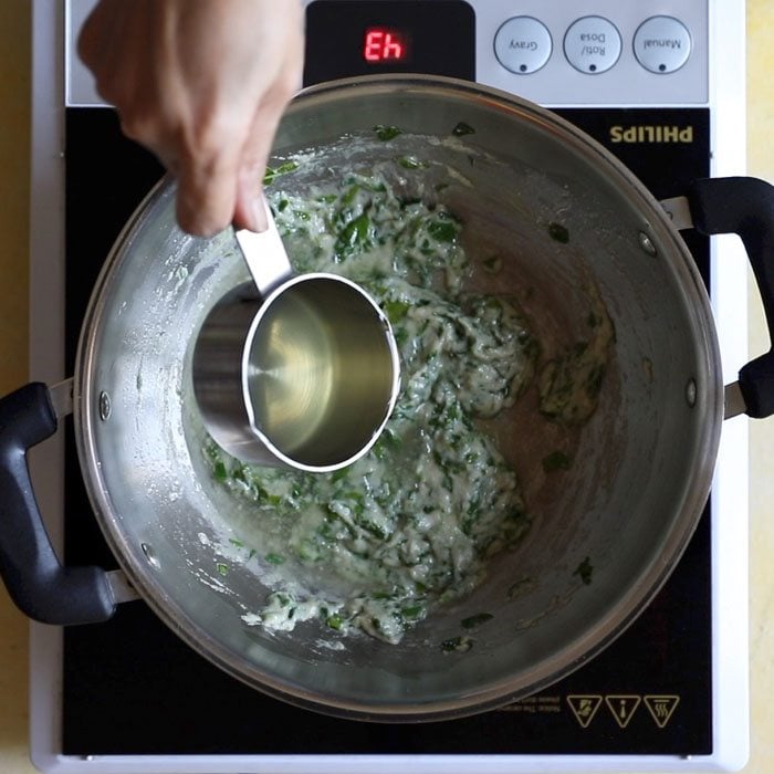 adding matar stock to pan with methi mixture.