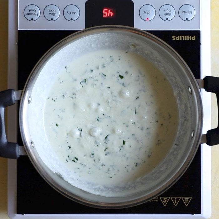 simmering methi matar malai in a kadai.