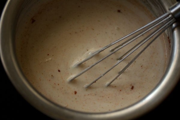 raita base is lightly pink from the addition of spices.