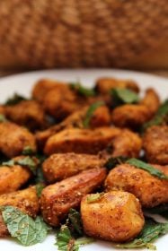 arbi sabji on a white plate with mint leaves garnish.