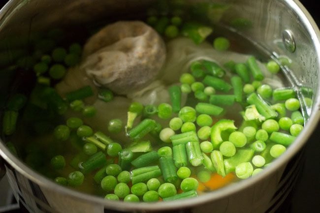 vegetables and spices bundle added to hot water in pot