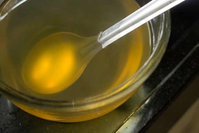 vegetable stock in a glass bowl with spoon inside