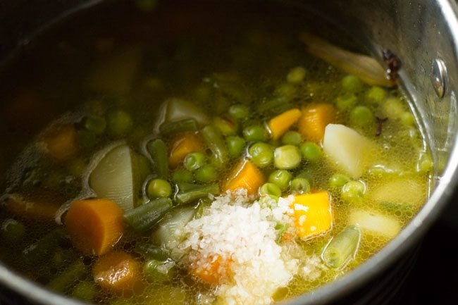 stock with vegetables and salt in pan