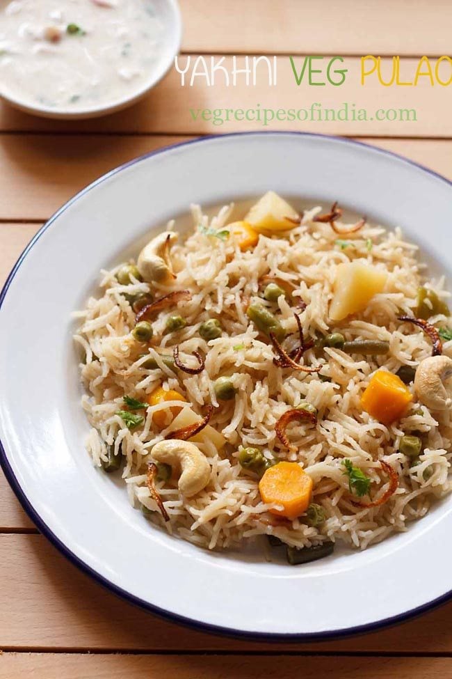 yakhni pulao garnished with fried onions in a white plate