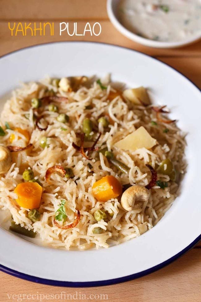 yakhni pulao garnished with fried onions and cashews in a white plate