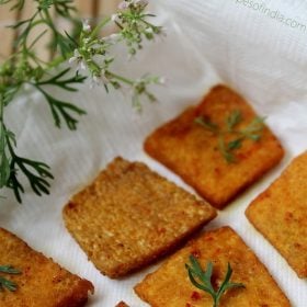 yam chips garnished with coriander leaves and served on a kitchen paper towel.