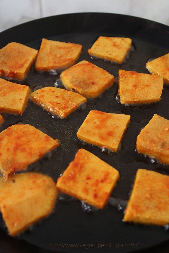 shallow frying marinated jimikand slices in hot oil. 