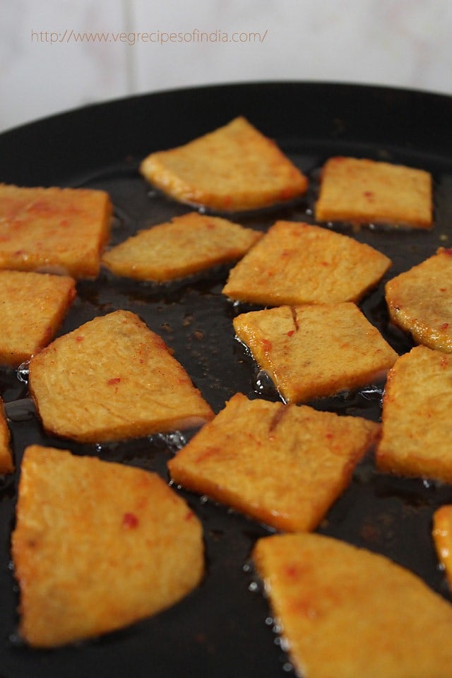 shallow frying marinated yam slices in hot oil. 