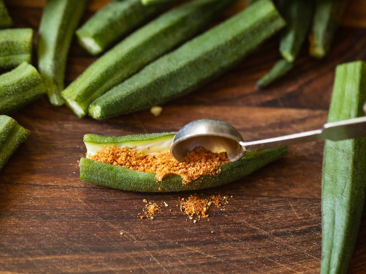 stuffing bhindi with prepared spice mixture.
