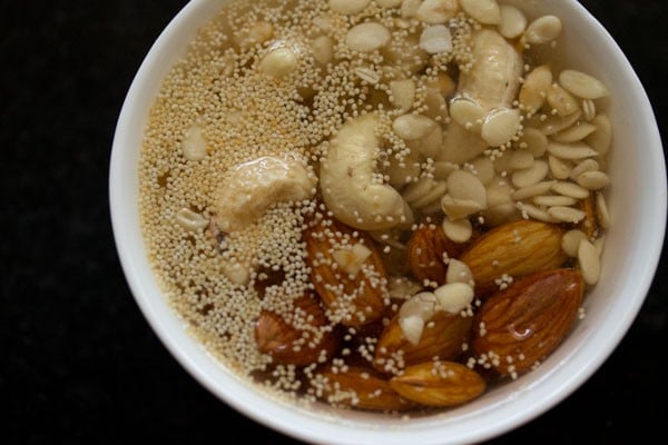 water added to bowl containing almonds cashews and khus khus