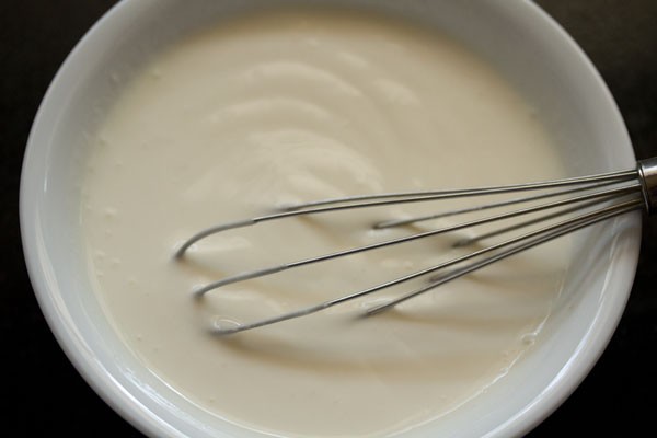curd in a small bowl with wired whisk
