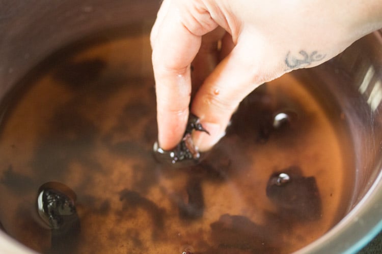 crushing and mashing the kokum flesh under water with fingers.