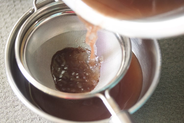 straining kokum extract for making sol kadhi recipe.